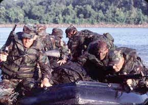 Army Divers in Zodiac boats secure an enemy shoreline in a river crossing training mission.  Army Divers sometimes act as a first line of engagement, much like Special Forces Soldiers.