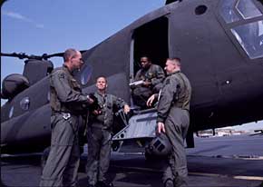 The CH-47 flight teamtwo 15U Crew Chiefs and two Pilotsdiscuss flight plans prior to a training mission. Crew Chiefs are essential to all Chinook flight missions and handle all maintenance and logistical tasks.